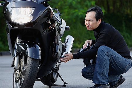 seniors motorcycle - Man looking at motorcycle Stock Photo - Premium Royalty-Free, Code: 656-01765295