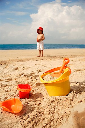 simsearch:841-03507749,k - Young boy on beach, beach bucket and toys in foreground Stock Photo - Premium Royalty-Free, Code: 656-01765293