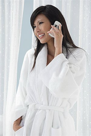 simsearch:656-01765881,k - Woman wearing bathrobe, standing in front of window, talking on phone Foto de stock - Royalty Free Premium, Número: 656-01765310
