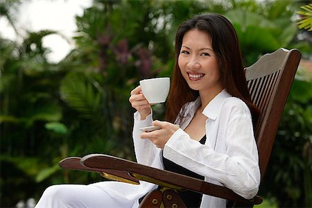 simsearch:656-01765502,k - Woman sitting outdoors, having a cup of tea, smiling at camera Stock Photo - Premium Royalty-Free, Code: 656-01765338