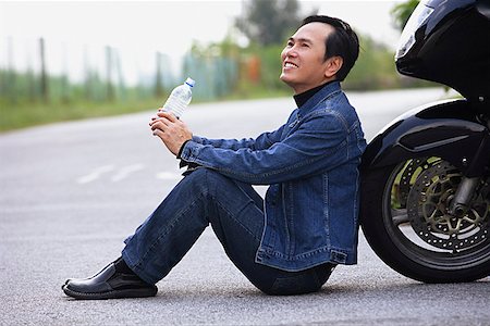 Homme appuyé contre moto, assis sur l'eau potable route Photographie de stock - Premium Libres de Droits, Code: 656-01765389