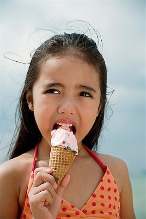 Young girl on beach eating an ice cream cone Stock Photo - Premium Royalty-Free, Code: 656-01765394