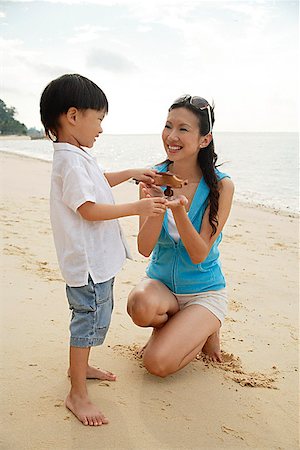 simsearch:841-03507749,k - Mother and son on beach, boy holding wooden airplane Stock Photo - Premium Royalty-Free, Code: 656-01765455