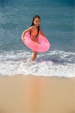 playing hot tubes - Young girl on beach carrying pink float around waist Stock Photo - Premium Royalty-Free, Code: 656-01765459