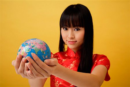 simsearch:656-01765511,k - Young woman wearing red cheongsam and holding globe in the palm of her hands Stock Photo - Premium Royalty-Free, Code: 656-01765452