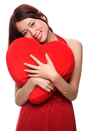 simsearch:656-01765511,k - Young woman hugging red heart shaped pillow Stock Photo - Premium Royalty-Free, Code: 656-01765577