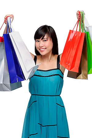 simsearch:656-01765511,k - Young woman wearing blue dress and holding shopping bags up in air Stock Photo - Premium Royalty-Free, Code: 656-01765598