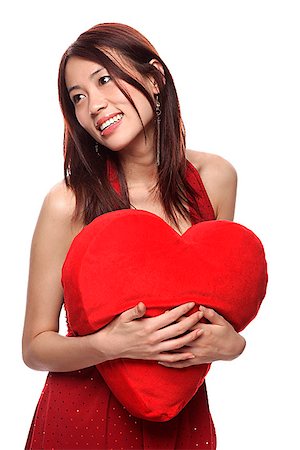 simsearch:656-01765511,k - Young woman holding red heart shaped pillow, looking away Stock Photo - Premium Royalty-Free, Code: 656-01765615