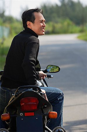 Man sitting on Motorcycle, looking away Stock Photo - Premium Royalty-Free, Code: 656-01765657