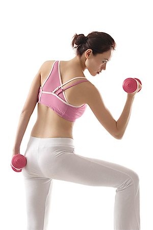 Woman with back to camera, lifting weights Stock Photo - Premium Royalty-Free, Code: 656-01765692