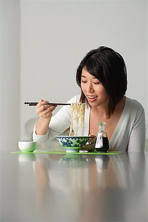 salsa de soja - Young woman eating a bowl of noodles Foto de stock - Sin royalties Premium, Código: 656-01765702