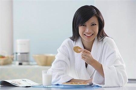 simsearch:656-01765881,k - woman in kitchen wearing bathrobe holding cooking, smiling at camera, reading magazine Foto de stock - Royalty Free Premium, Número: 656-01765764