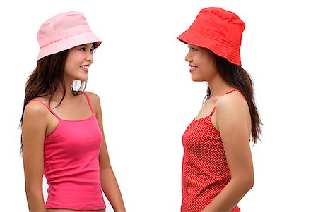 simsearch:656-01765511,k - Two young women wearing pink and red hats, looking at each other Stock Photo - Premium Royalty-Free, Code: 656-01765777
