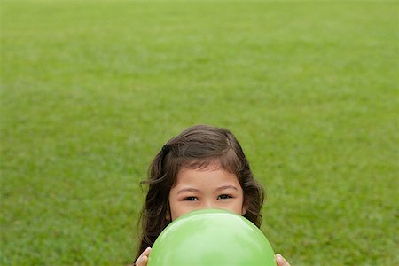 elio - Girl hiding behind green balloon Fotografie stock - Premium Royalty-Free, Codice: 656-01765824