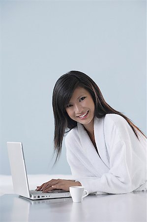 simsearch:656-01765881,k - woman wearing bathrobe, smiling and working on laptop computer, smiling at camera Foto de stock - Royalty Free Premium, Número: 656-01765844