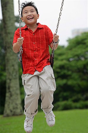 Boy on playground swing, smiling Stock Photo - Premium Royalty-Free, Code: 656-01765843