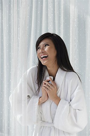 simsearch:656-01765881,k - woman in bathrobe, holding phone to chest and laughing Foto de stock - Royalty Free Premium, Número: 656-01765906