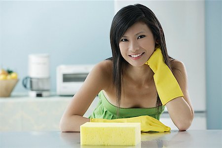 straight hair - woman in kitchen with sponge, wearing gloves, looking at camera smiling Stock Photo - Premium Royalty-Free, Code: 656-01765941