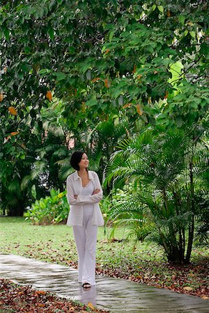 simsearch:656-01765715,k - A woman strolls down a path in a garden Stock Photo - Premium Royalty-Free, Code: 656-01765996