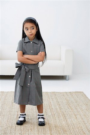 Une jeune fille habillée en uniforme scolaire croise ses bras Photographie de stock - Premium Libres de Droits, Code: 656-01765999