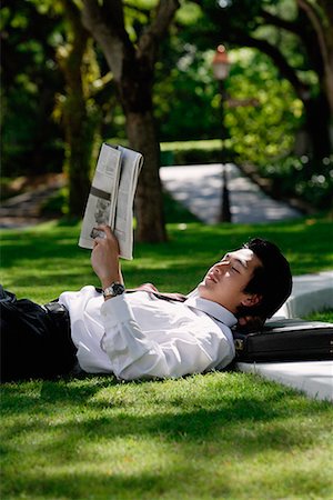 simsearch:656-01766020,k - A man lies down and reads the newspaper in the park Foto de stock - Sin royalties Premium, Código: 656-01766037