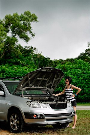 problème de voiture - Une femme contrôle sous le capot de sa voiture Photographie de stock - Premium Libres de Droits, Code: 656-01766073