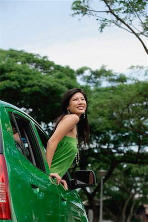 A young woman leans out of the window of a car Stock Photo - Premium Royalty-Free, Code: 656-01766083