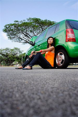 problème de voiture - Une jeune femme est assise sur le sol, appuyé contre une voiture Photographie de stock - Premium Libres de Droits, Code: 656-01766123