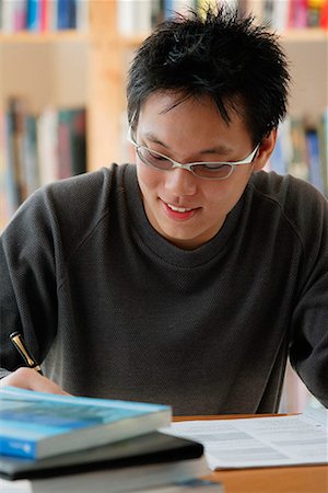 simsearch:656-01766118,k - A young man studies in the library Foto de stock - Royalty Free Premium, Número: 656-01766158