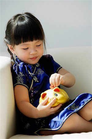 simsearch:656-01766387,k - Une petite fille en bleu cheongsam soie joue avec une tirelire Photographie de stock - Premium Libres de Droits, Code: 656-01766185