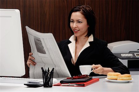 A woman takes a break at work and reads the newspaper Stock Photo - Premium Royalty-Free, Code: 656-01766199