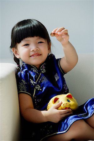 simsearch:656-01766387,k - Une petite fille en bleu cheongsam soie joue avec une tirelire Photographie de stock - Premium Libres de Droits, Code: 656-01766200