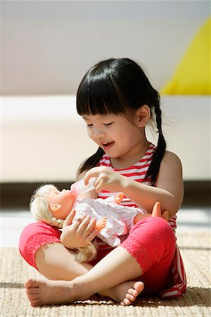 feminine young girl - A small girl plays with a doll Stock Photo - Premium Royalty-Free, Code: 656-01766215