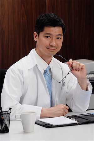 A doctor sits at his desk Stock Photo - Premium Royalty-Free, Code: 656-01766211