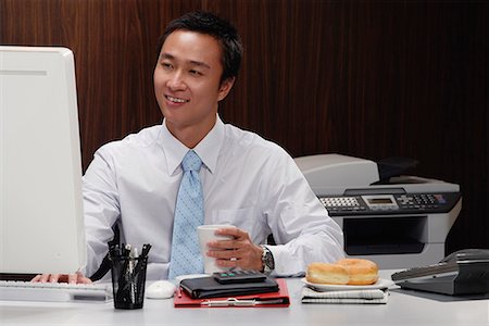 simsearch:656-01766255,k - A man has a hot drink while he works at his desk Stock Photo - Premium Royalty-Free, Code: 656-01766274