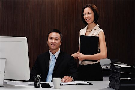 executive mentor - A man and a woman smile at the camera while they are at work Stock Photo - Premium Royalty-Free, Code: 656-01766296