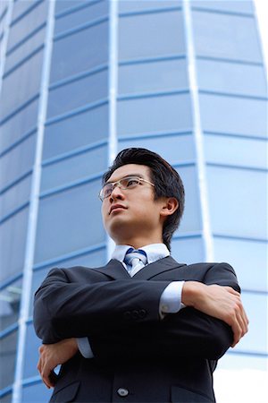 A man with a suit stands in front of a skyscraper Stock Photo - Premium Royalty-Free, Code: 656-01766298