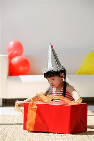 simsearch:656-01766387,k - Une jeune fille déballe un cadeau d'anniversaire Photographie de stock - Premium Libres de Droits, Code: 656-01766314