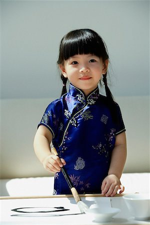 simsearch:656-01766387,k - Une petite fille en bleu cheongsam soie écriture de calligraphie chinoise Photographie de stock - Premium Libres de Droits, Code: 656-01766330