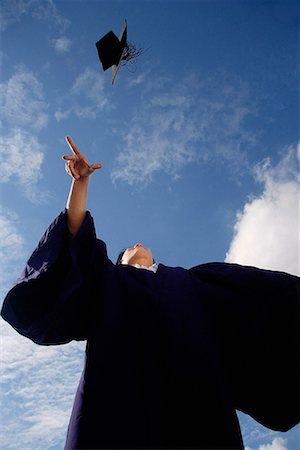 A recent graduate throws his hat in the air in celebration Stock Photo - Premium Royalty-Free, Code: 656-01766377