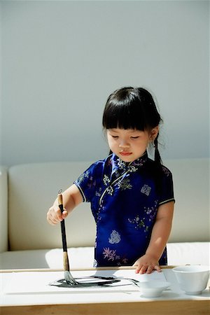 simsearch:656-01766387,k - Une petite fille en bleu cheongsam soie écriture de calligraphie chinoise Photographie de stock - Premium Libres de Droits, Code: 656-01766387