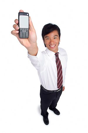 showing his teeth - A man smiles at the camera as he holds out his cellphone Stock Photo - Premium Royalty-Free, Code: 656-01766452