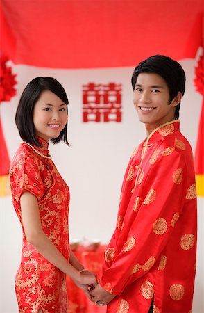 Un couple de jeunes mariés tiennent par la main et sourire à la caméra Photographie de stock - Premium Libres de Droits, Code: 656-01766460
