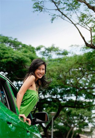 A young woman leans out of the window of a car Stock Photo - Premium Royalty-Free, Code: 656-01766527
