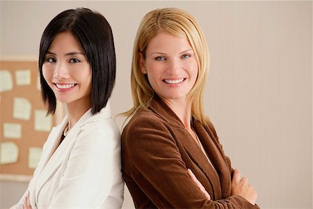 simsearch:655-01781557,k - Deux collègues féminines sourient à la caméra ensemble Photographie de stock - Premium Libres de Droits, Code: 656-01766620