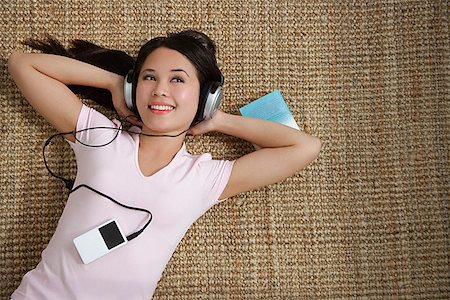 someone laying down aerial view - Young woman listening to music while lying down Stock Photo - Premium Royalty-Free, Code: 656-01766643