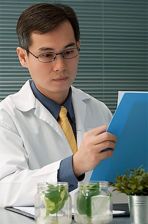 Scientist examining jar with plant samples Stock Photo - Premium Royalty-Free, Code: 656-01766679