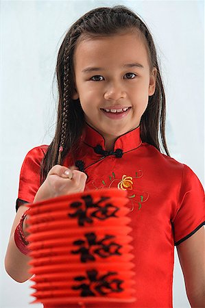 Young girl in traditional Chinese dress holding red lantern and looking at camera Stock Photo - Premium Royalty-Free, Code: 656-01766672