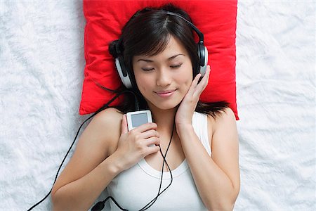 someone laying down aerial view - Young woman listening to music Stock Photo - Premium Royalty-Free, Code: 656-01766706