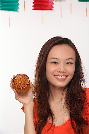 Young woman with Chinese lantern smiling at camera Stock Photo - Premium Royalty-Free, Code: 656-01766839